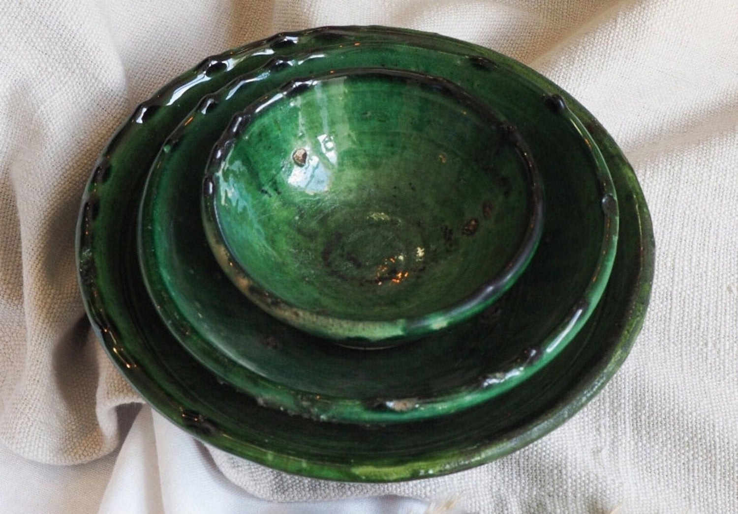 three-tamagroute-pottery-bowls-stacked-on-white-linen-cloth
