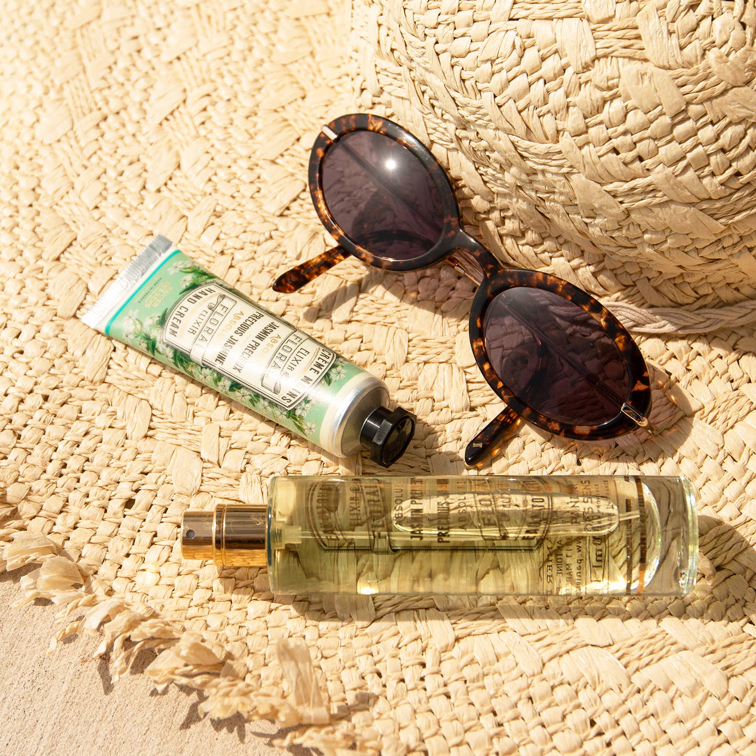 image-of-straw-hat-with-sun-glasses,-hand-cream-and-perfume spray