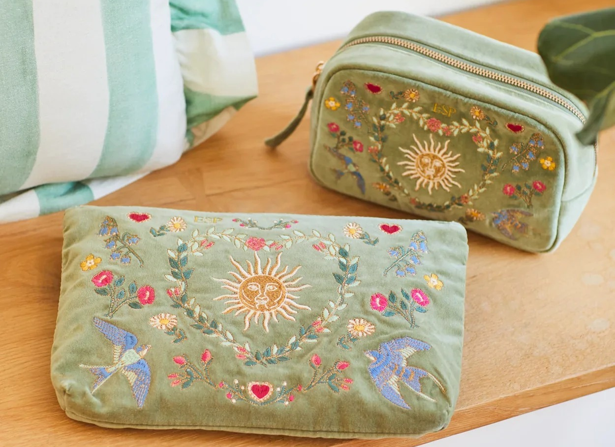 everyday-velvet-pouch-and-washbag-with -fllowers-sun-bird-embroidery-on-wood-shelf-stripe-cushion-in-background