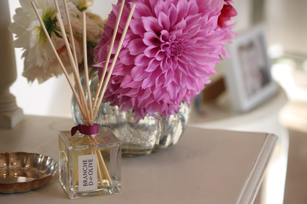 Diffuser with pink flowers and 'Branche d'Olive' label on a surface