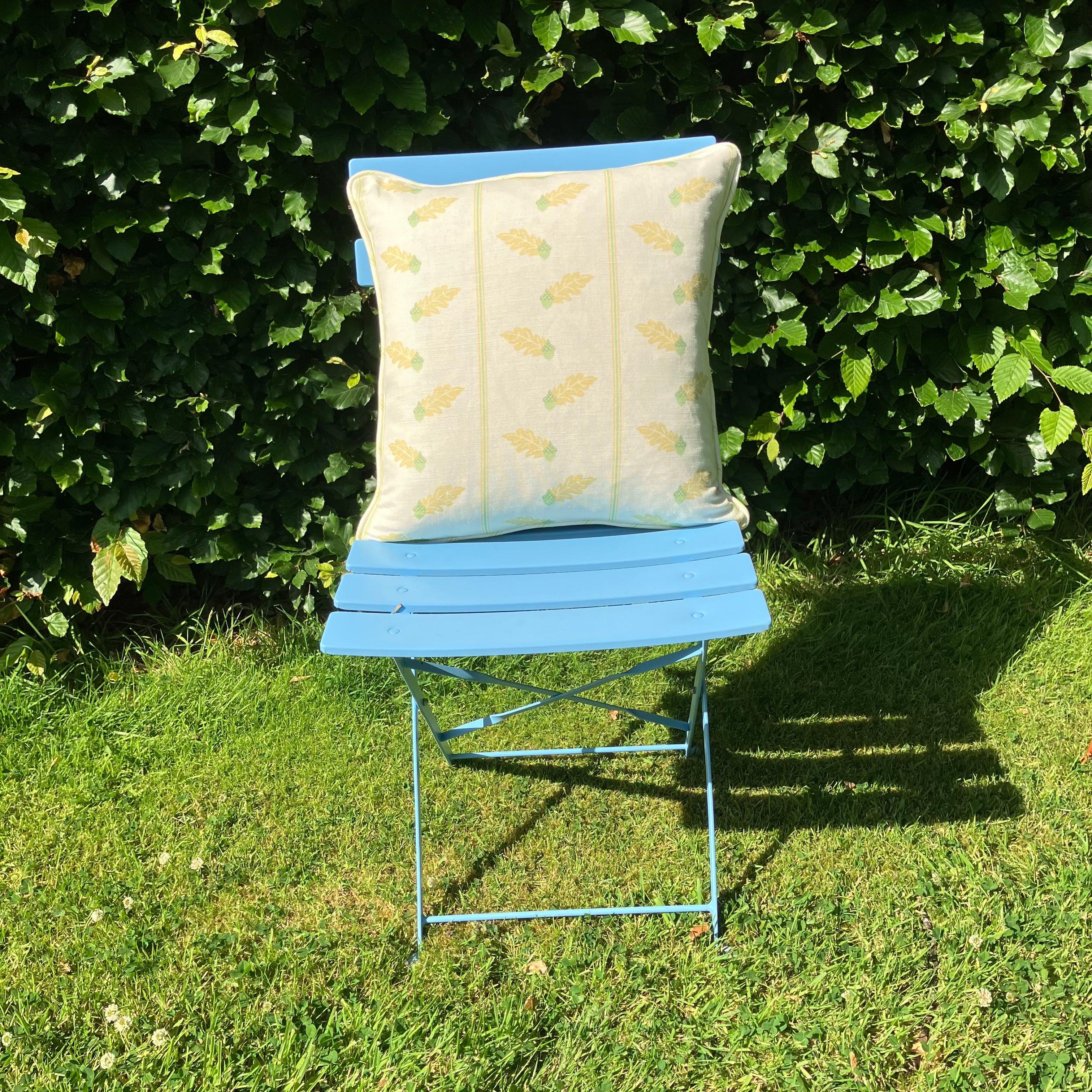 Yellow Cushion on blue chair on lawn