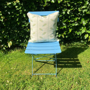 Green cushion on blue chair on grass