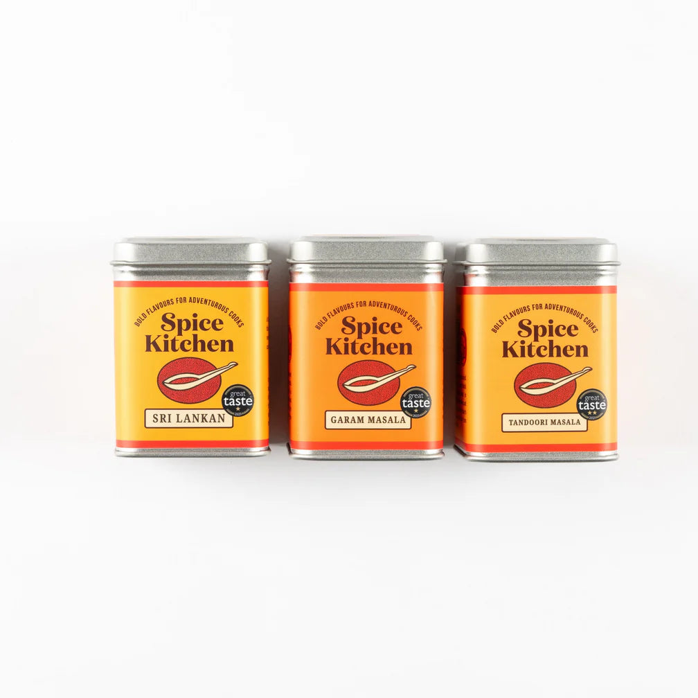 Three cans of Spice Kitchen spice blends on a white background