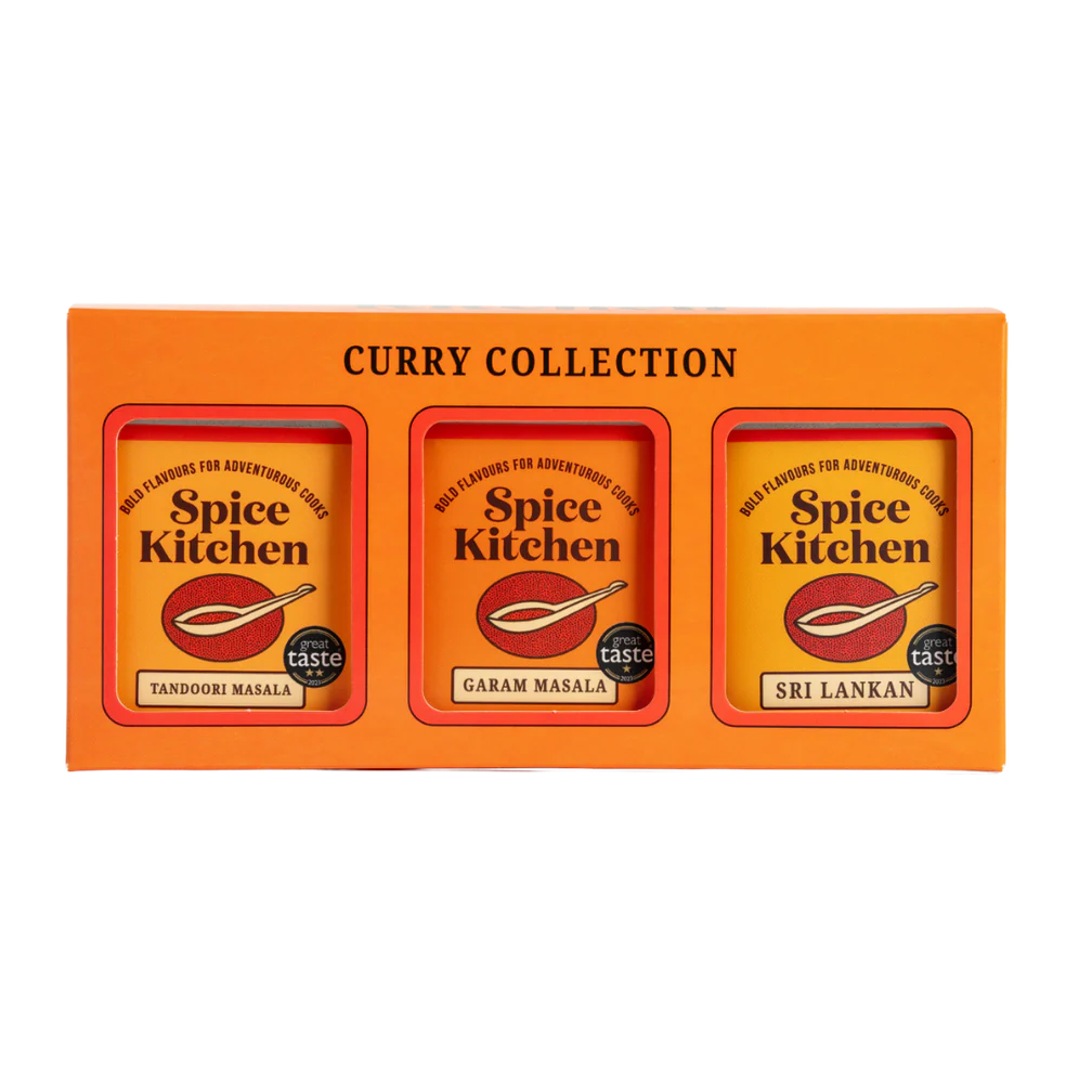 Orange box of Spice Kitchen Curry Collection with three spice packets inside.