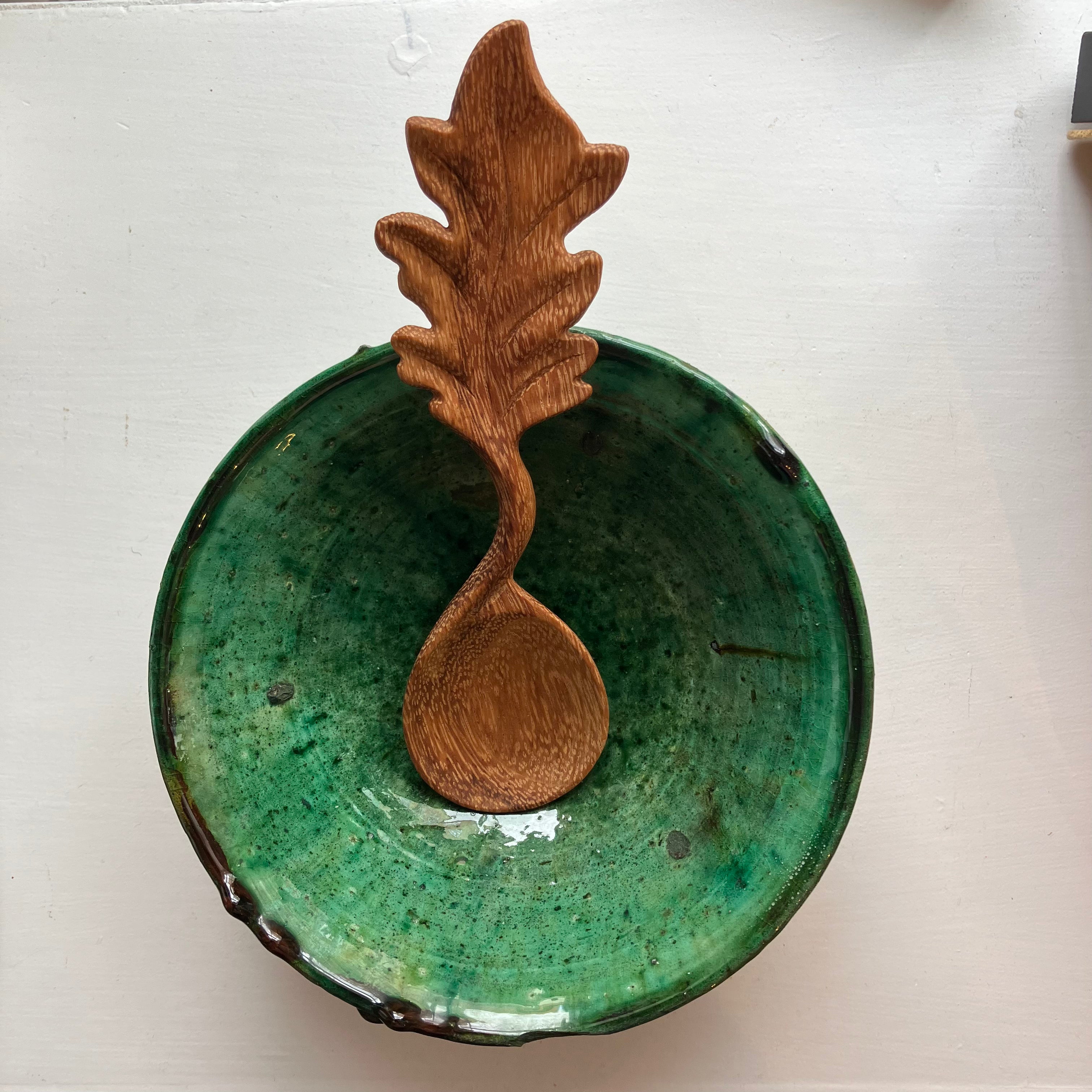 Wooden leaf handle spoon in green bowl