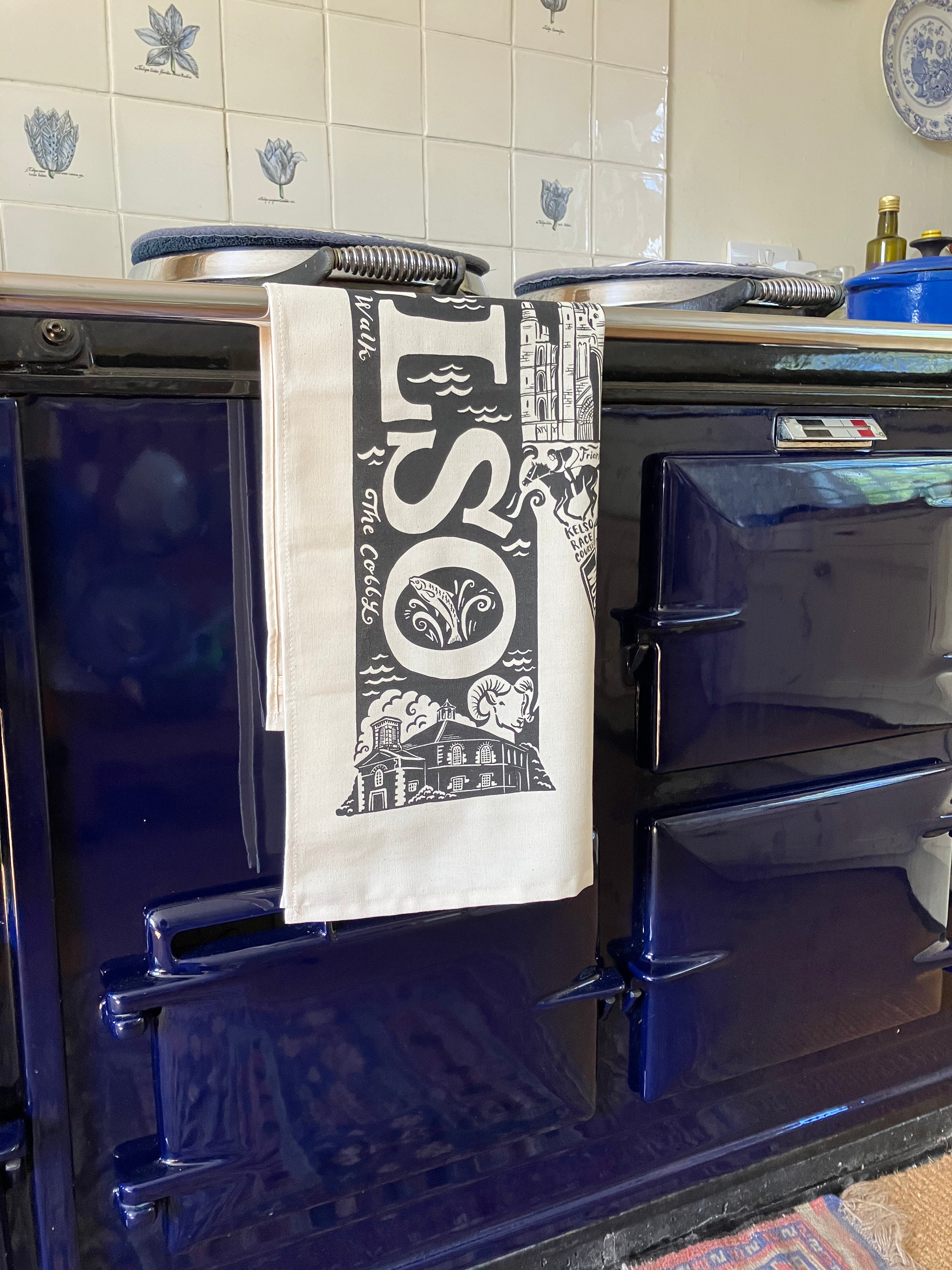 Tea towel with 'LSO' design hanging on a blue Aga range cooker.