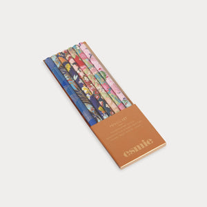 Set of colorful makeup brushes in a branded case on a light gray background