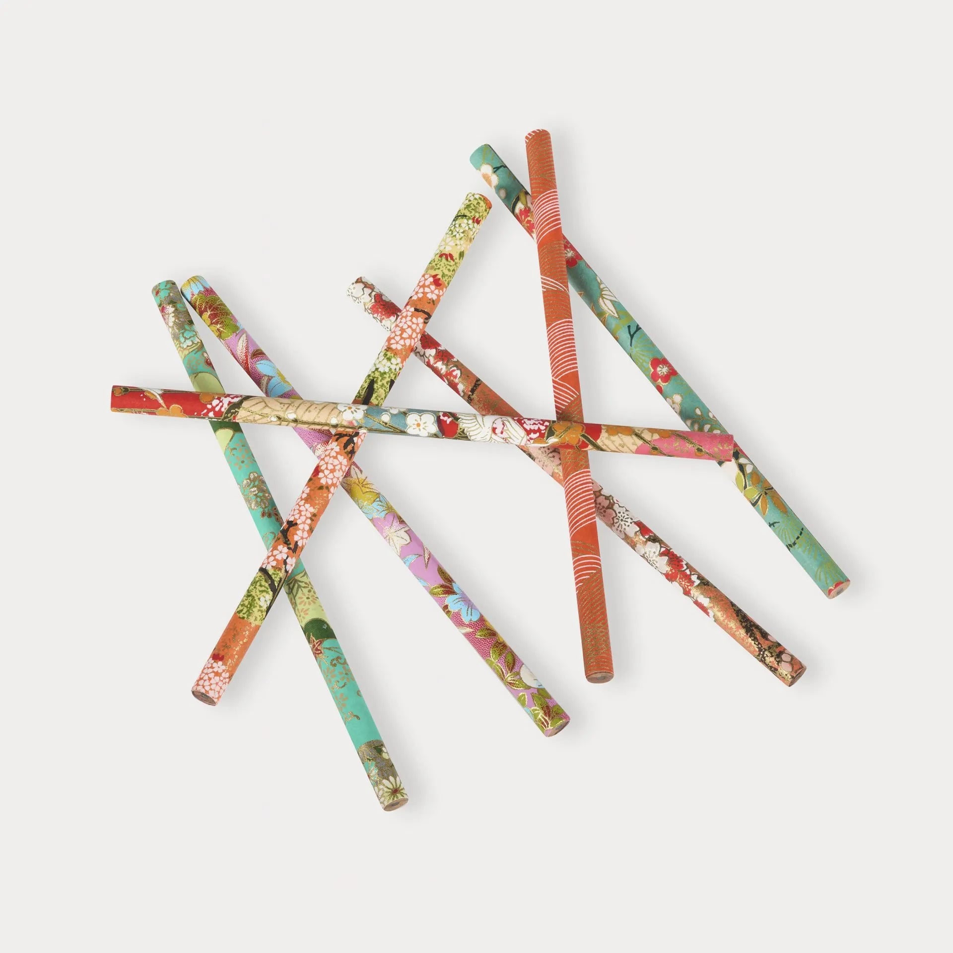 Colorful patterned straws arranged on a white background