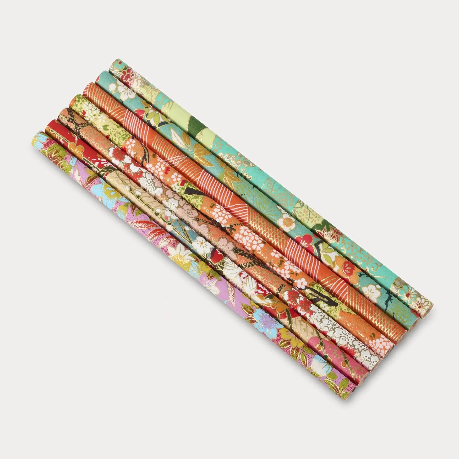 Set of colorful floral-patterned paper rolls on a white background