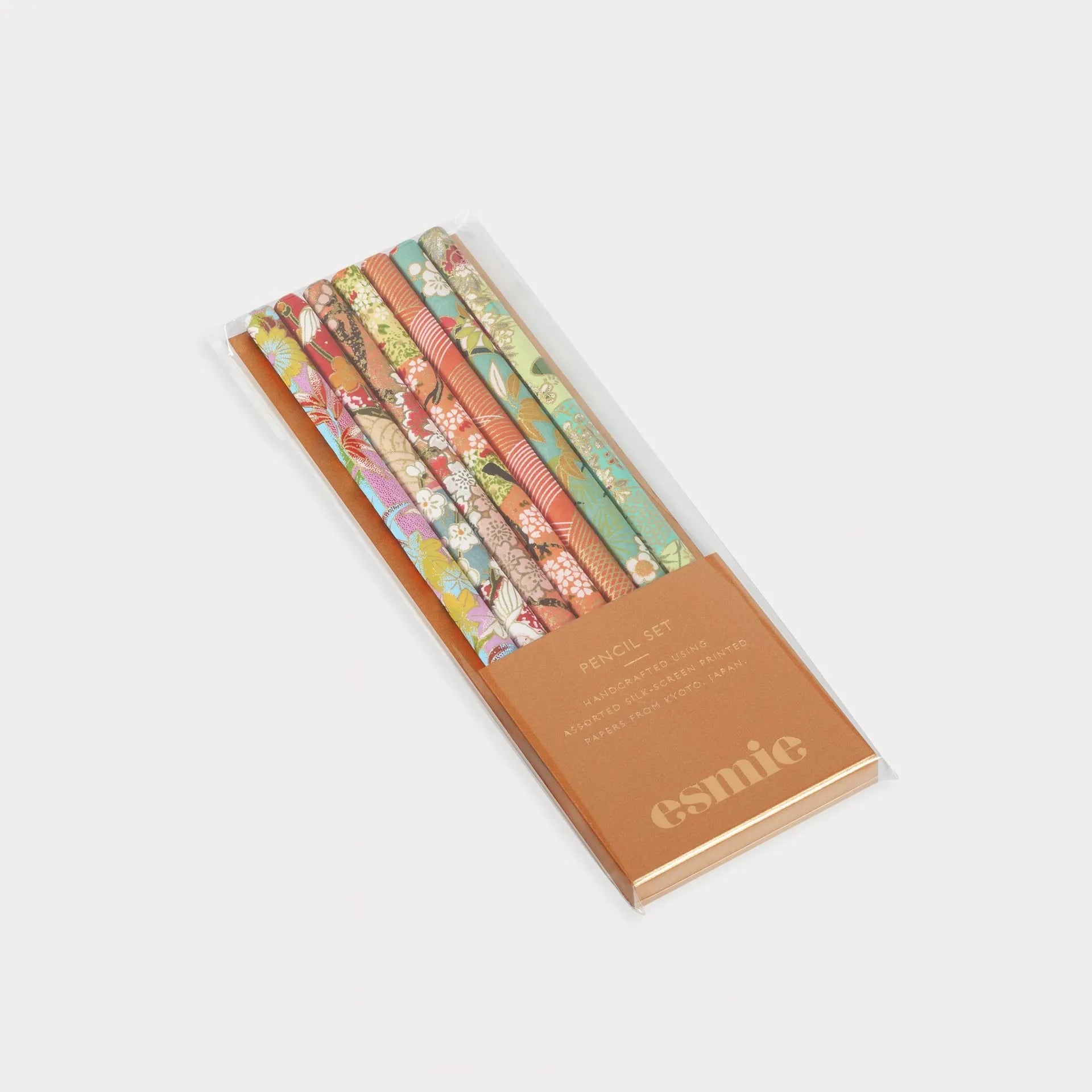 Set of colorful nail polish bottles in a branded box on a white background