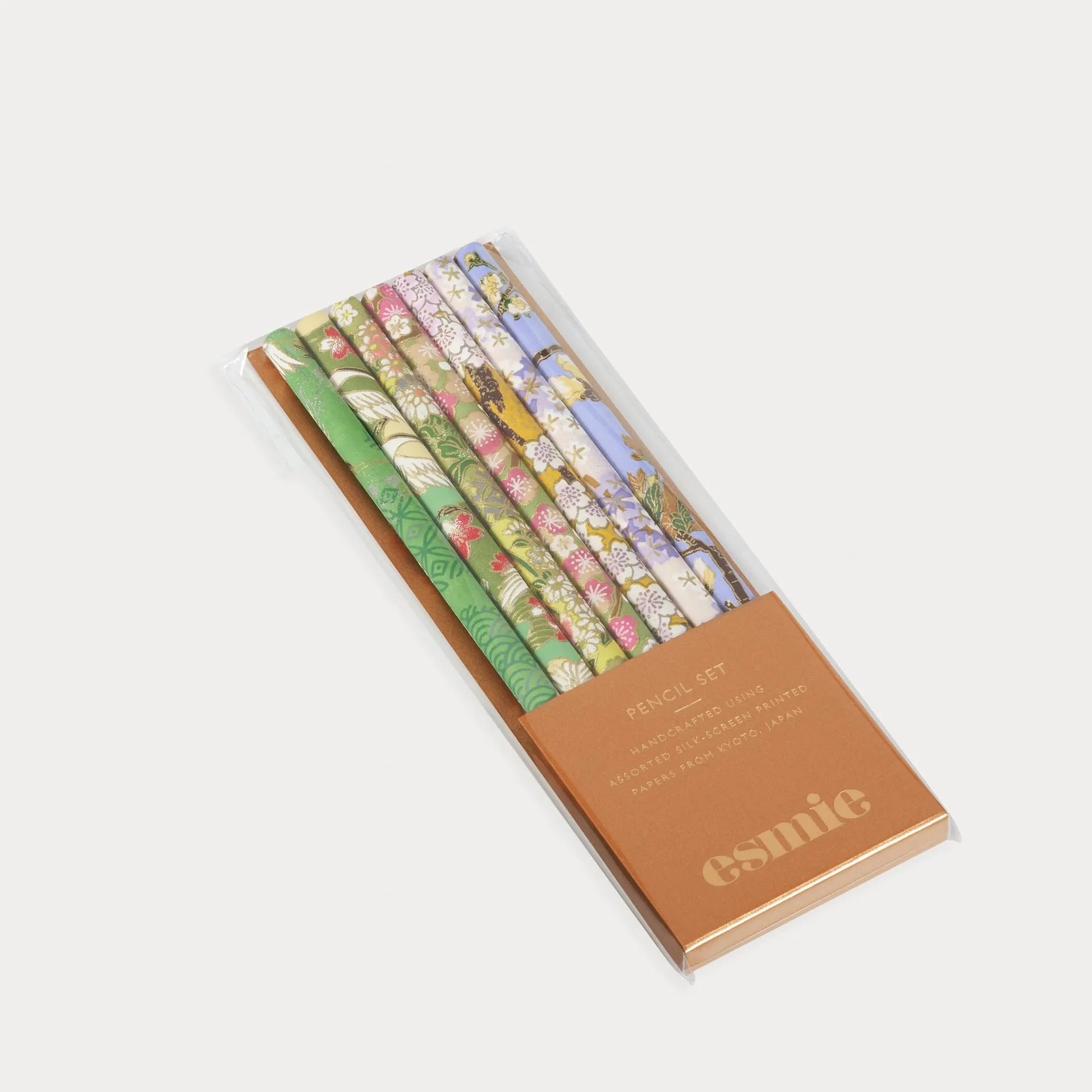 Set of colorful pencils in a brown box with 'esmie' branding on a white background
