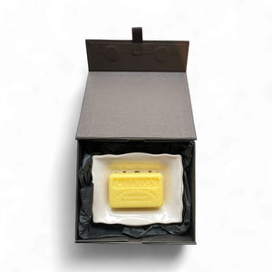 Yellow soap bar in a black box on a white background