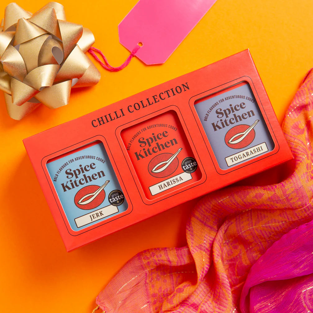 Spice Kitchen Chilli Collection with Harissa, Jerk, and Togarashi on an orange background with a gold bow and pink tag.