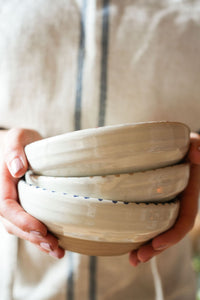 three-pottery-bowls-stacked-held-in-hands