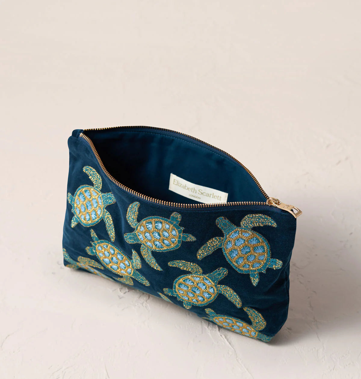 Blue pouch with turtle pattern on a light background