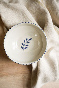 pottery-bowl-with-blue-dot-rim-sprig-inside-on-wooden-top-with -linen-cloth